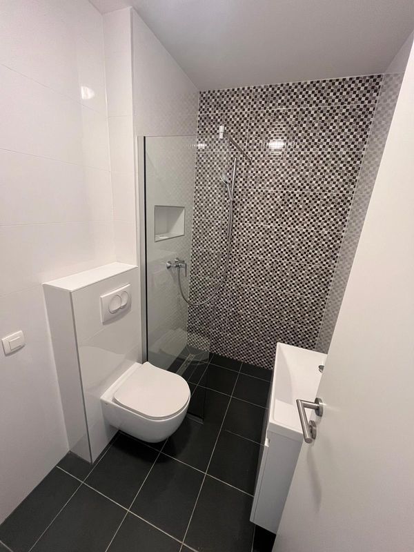 Moderna kupaonica s crno-bijelim mozaik pločicama i walk-in tušem - renovacija kupaonice Zagreb