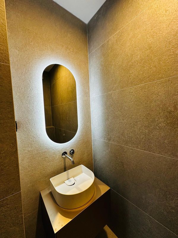 Moderni umivaonik s LED ogledalom i tamnim pločicama - adaptacija kupaonice Zagreb