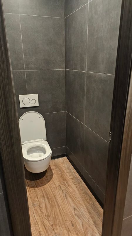 WC adaptacija s tamnim zidnim pločicama i drvenim podom - renovacija WC-a Zagreb, Mantofly